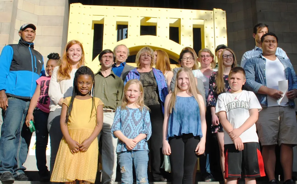 17th Annual Exhibit ARTwork winners pose in front of the Sister Bridge Replica parade float.