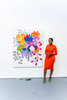 Tahirah Coleman standing next to large vibrant floral masterpiece