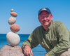 Photo of Peter Juhl with a stone balance sculptire