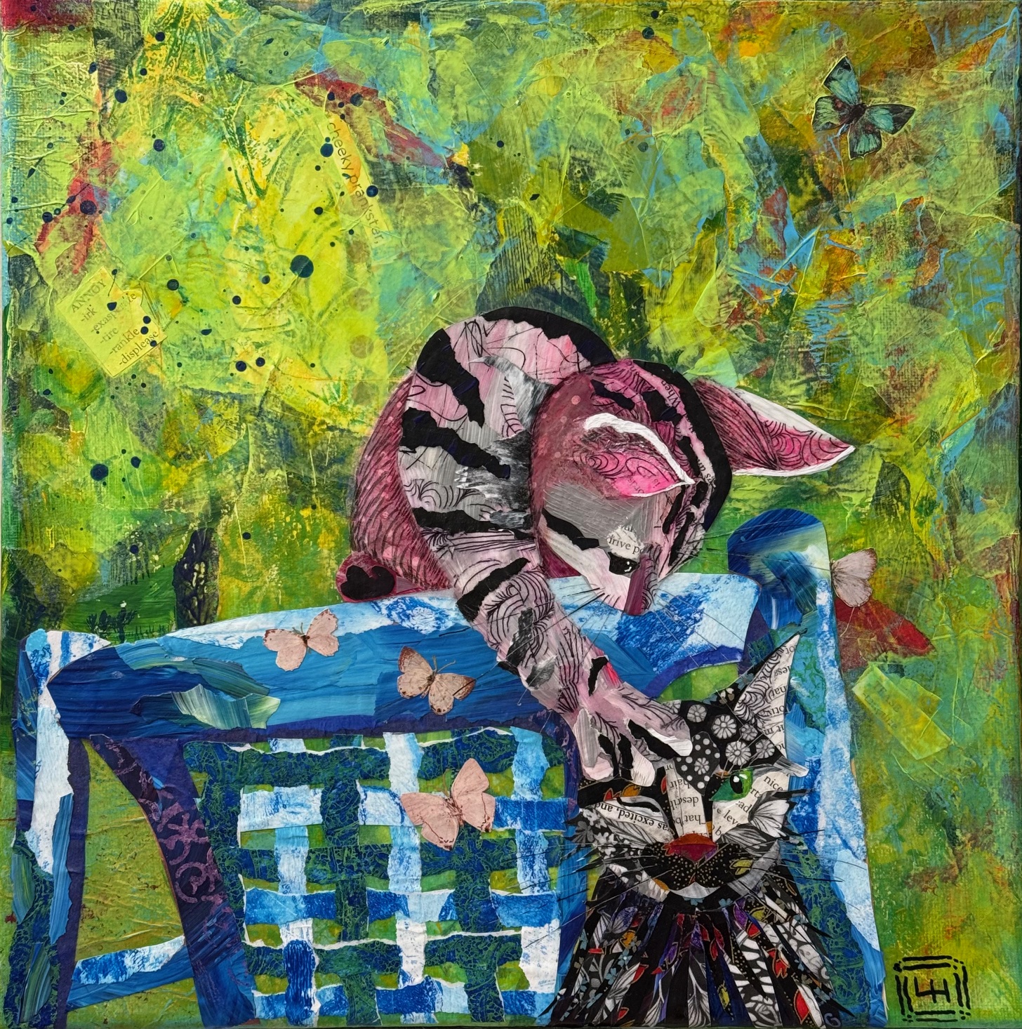 Torn paper collage of two playful cats on a blue chair