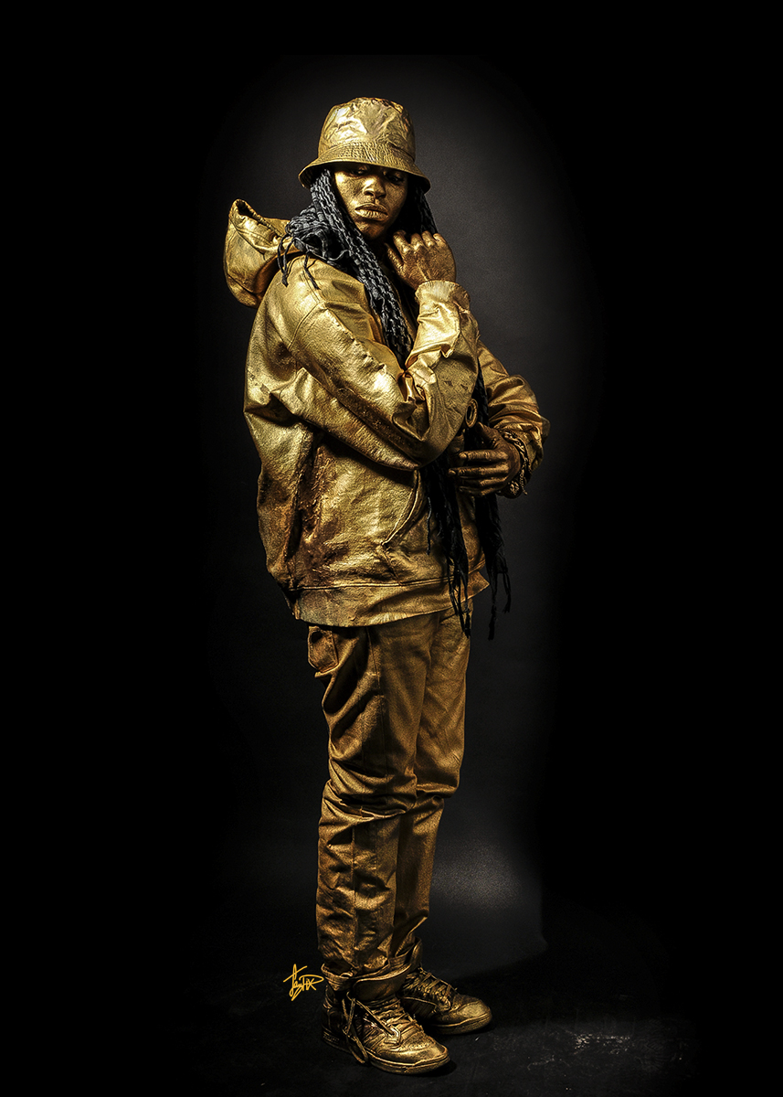 gold figure standing tall with head turned. right hand under chin , left hand under elbow