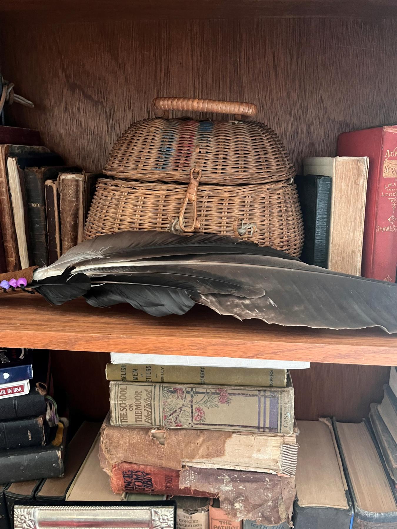 an old basket sits on a shelf with books