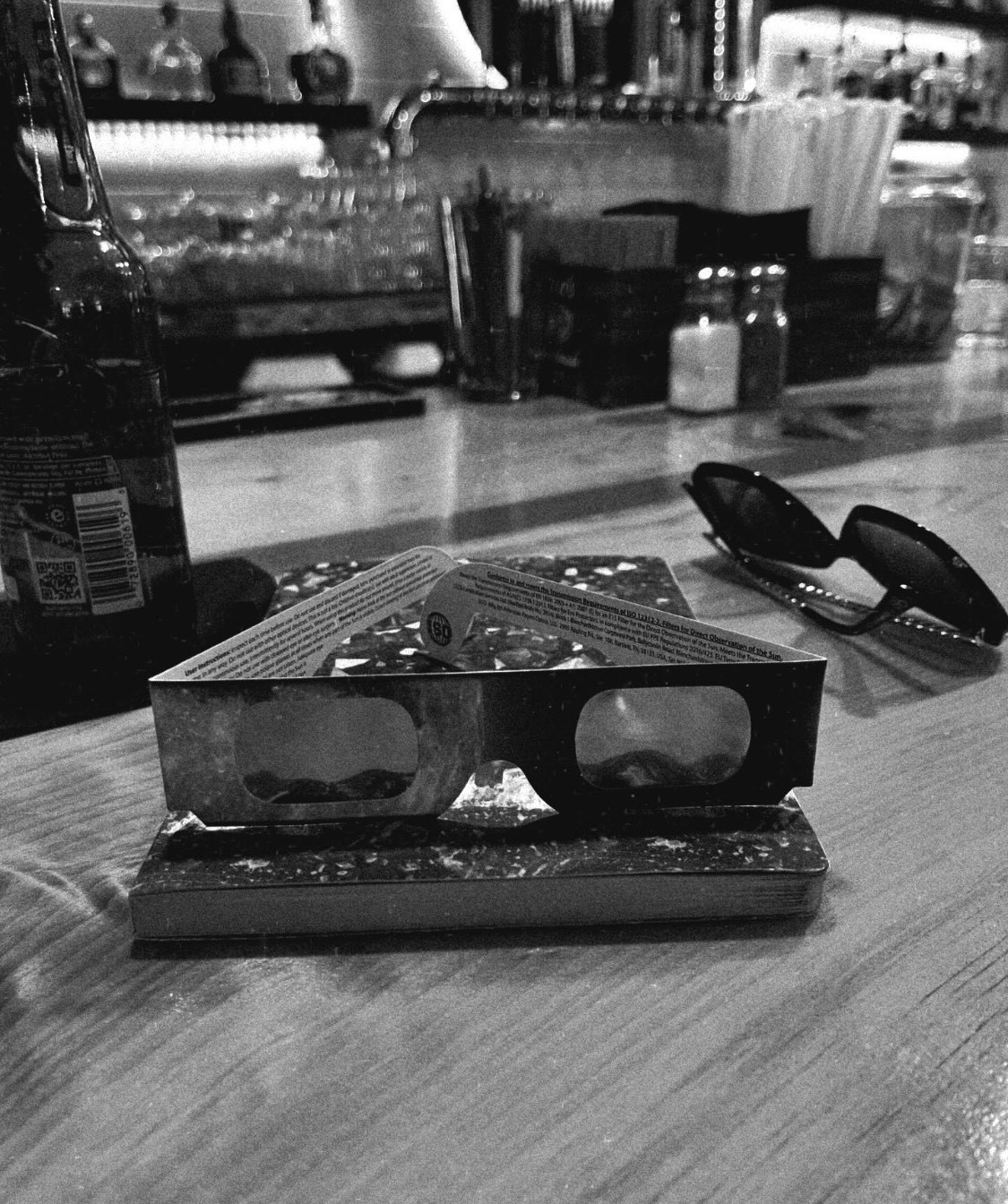 black and white image of solar eclipse glasses sits on a counter