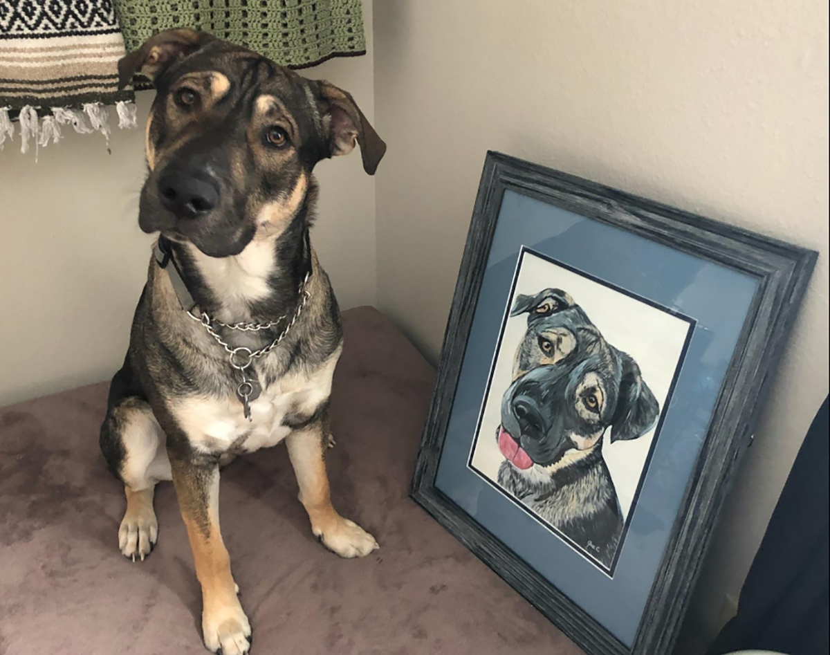 Dog poses with his painted portrait on canvas.