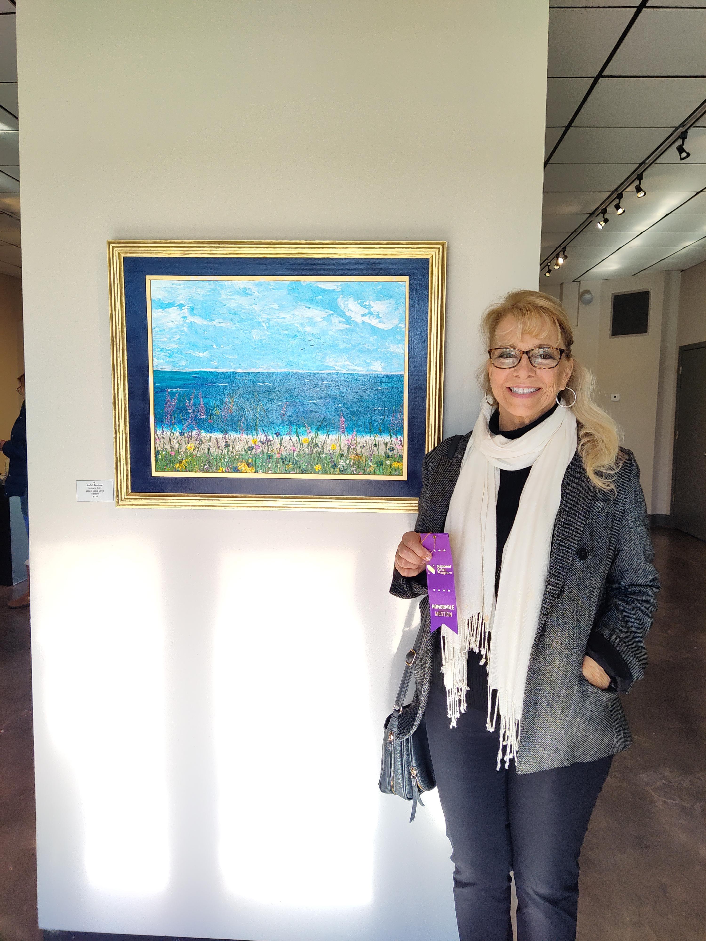ocean scene with blue sky filled with clouds and flowers in the foreground