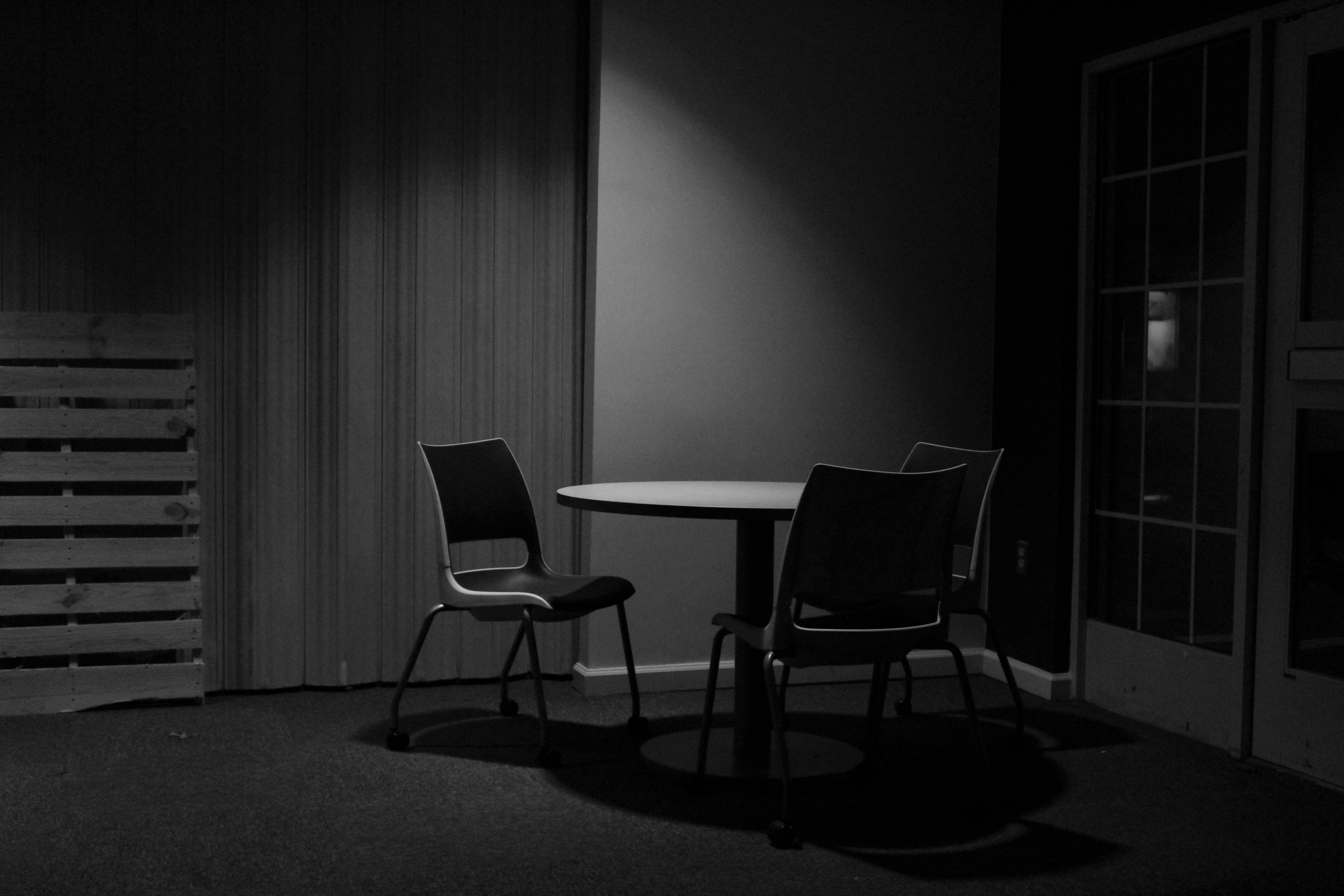 black and white photograph of an empty table and chairs