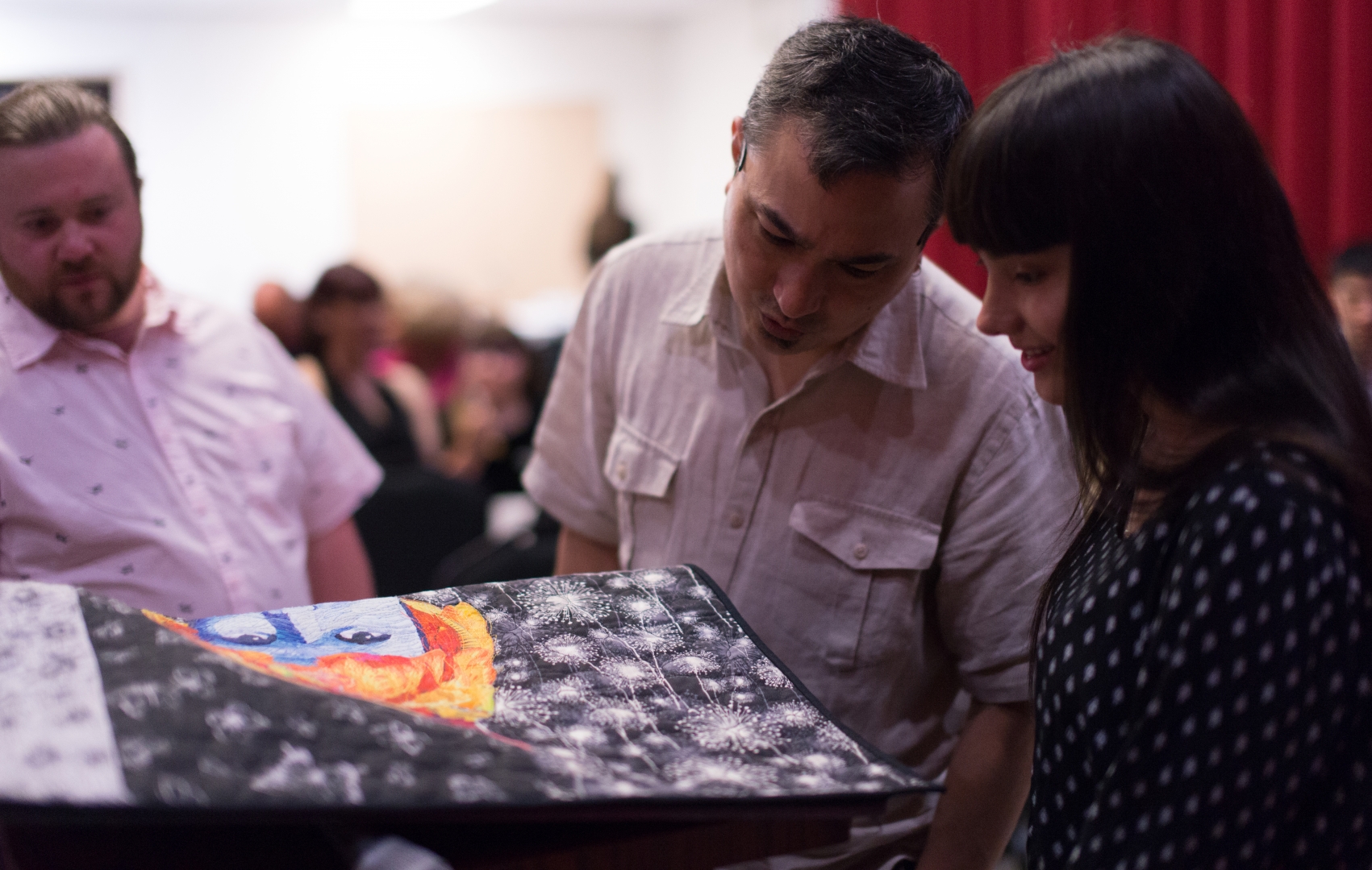 11th Annual Exhibit Attendees taking a closer look at the details of Jodi Davila's award winning textile piece.